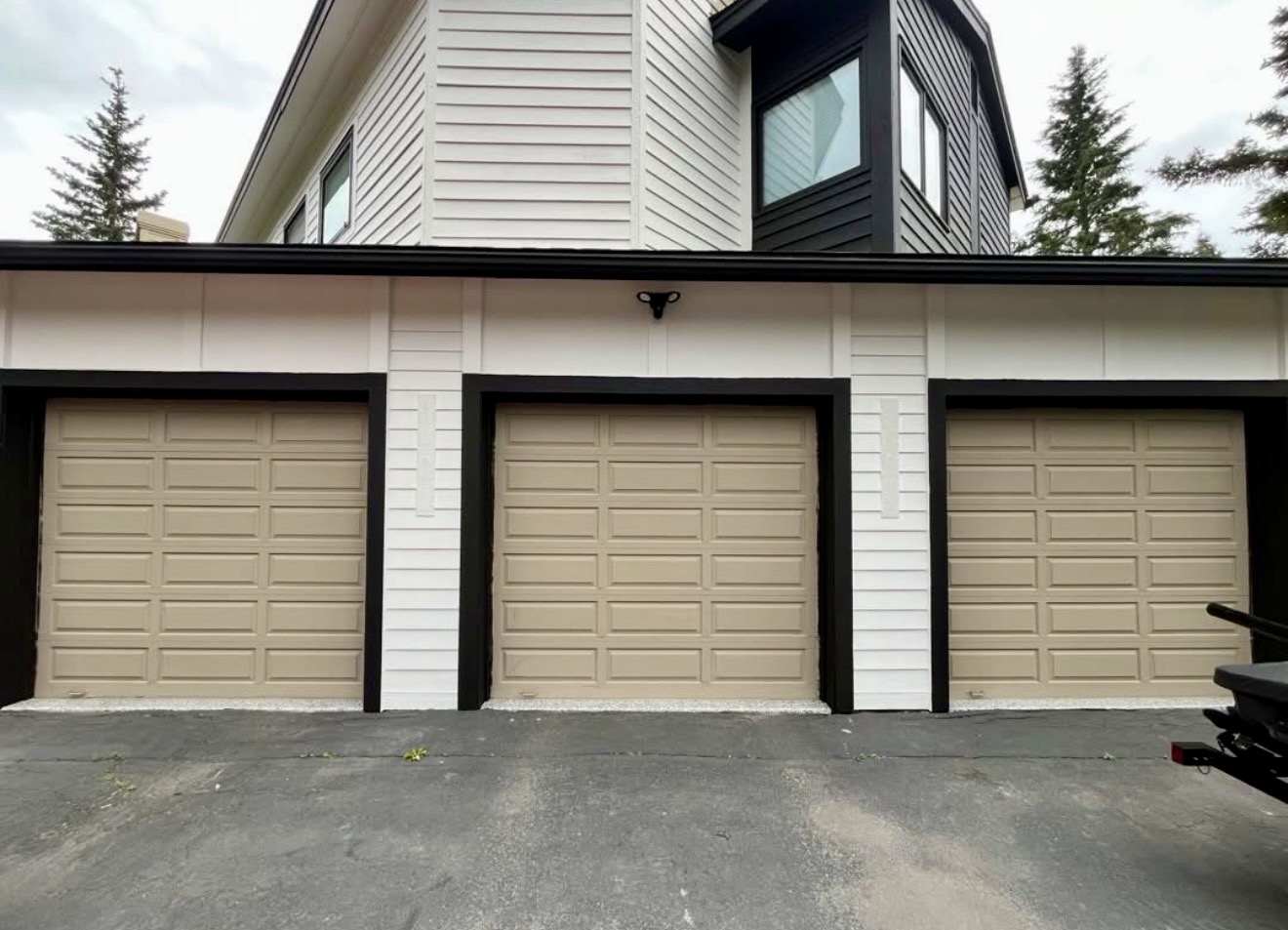 Three beige garage doors before replacement