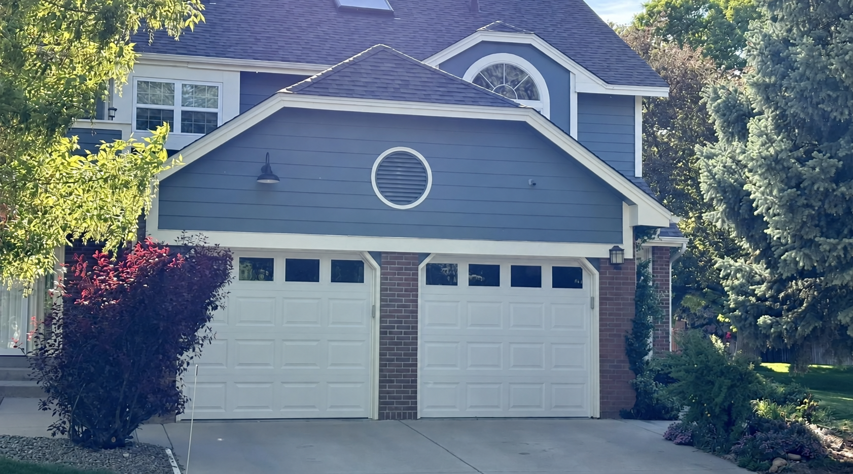 Two white garage doors on a blue Ohio home